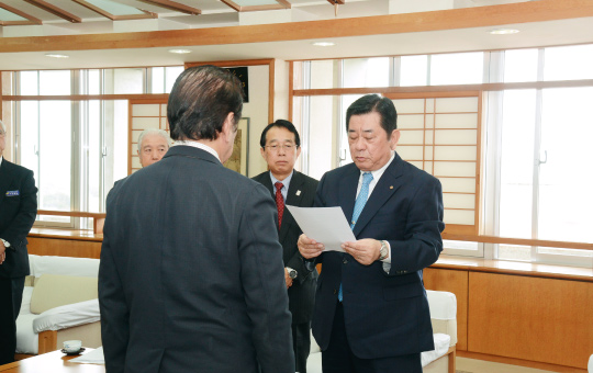 意見書を桑江市長に提出する新垣会長（右）