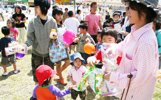 「元気に育つように」と笑顔でお菓子をもらう子どもたち