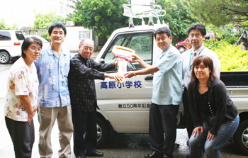 仲宗根会長（左）より山田校長（右）へ軽トラックが贈られた