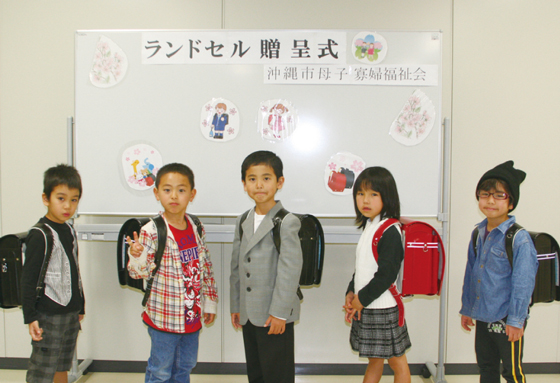 プレゼントされたランドセルを背負って 得意げにポーズをとるこども達