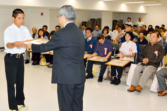 表彰を受けるコザ中学校生徒会の高宮城優くん（左）