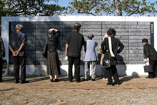 戦没者の名前をたどる遺族の方々（中央公園内「慰霊之塔」、2013年10月）