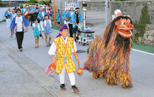 大勢の区民と共に地区を練り歩く獅子