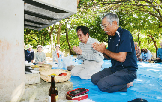 手を合わせて祈る青那志共栄会の大工廻会長（右）達