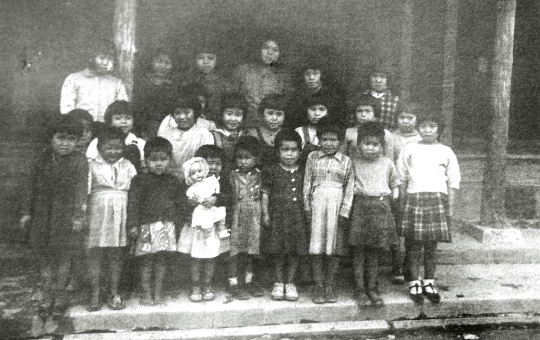 1947年ごろのコザ孤児院。ララ物資より暖かそうな服やお人形が届いた！【写真：沖縄県公文書館 所蔵】