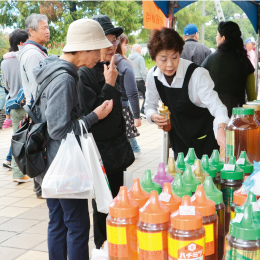 沖縄市の物産コーナーでは多くの人が蜂蜜や泡盛を買い求めた