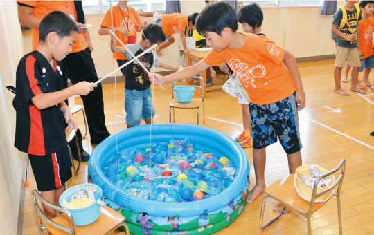 お父さんと遊ぼうコーナーで魚釣りゲームを楽しむこどもたち