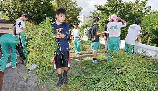 知花橋沿いで草木を運ぶ中学生達